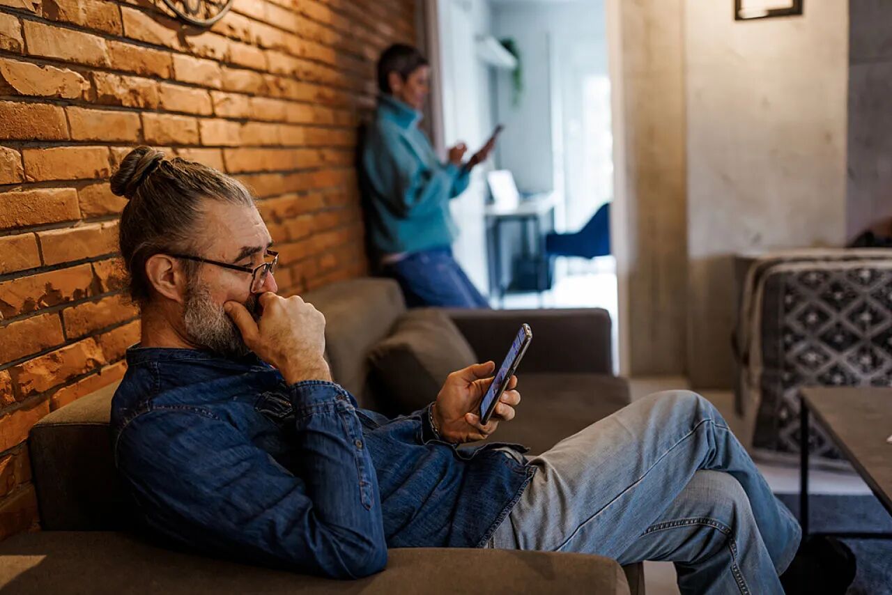 夫妻双双沉迷于手机,而缺少互相的关注。视觉中国|图